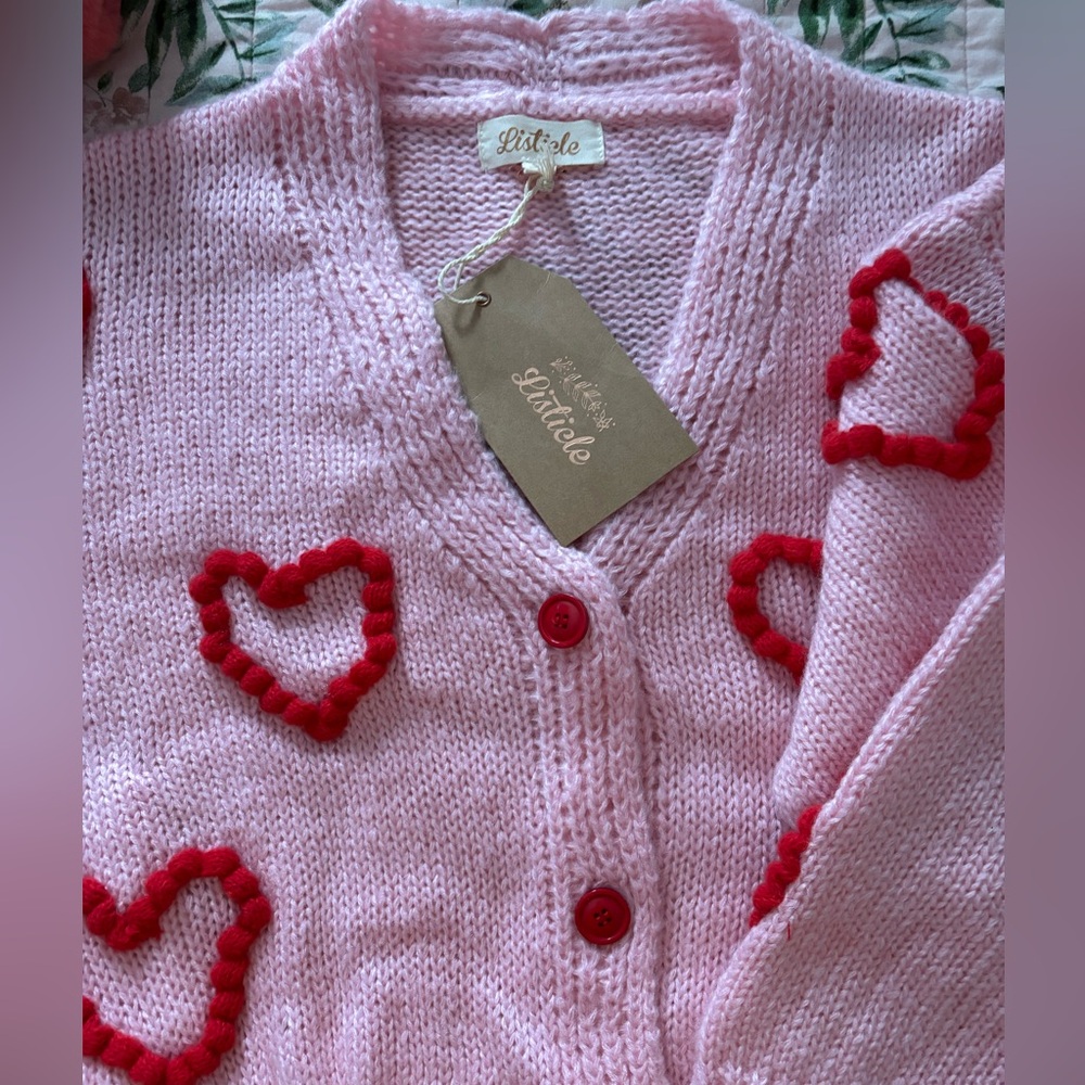 Pink sweater with red pompom hearts